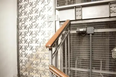a metal stair railing next to a wall at Restart Accommodations Colonna e Ludovisi in Rome