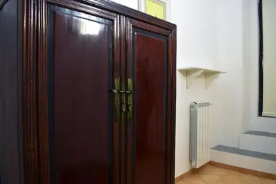 a brown wooden cabinet in a room with a staircase at Appartamento a Piazza Navona in Rome