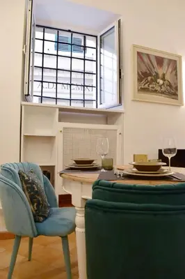 a dining room with a table and a blue chair at Appartamento a Piazza Navona in Rome