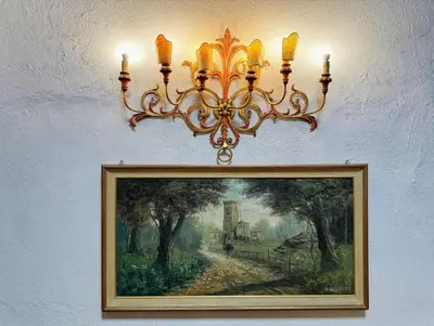 a chandelier hanging on a wall with a painting at Nice 2 CU in Rome
