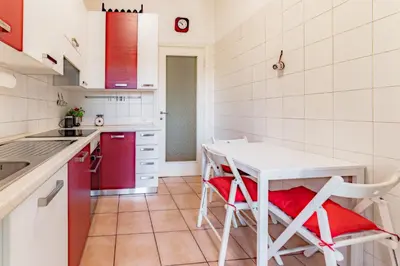 a kitchen with a white table and red appliances at Marta Suite - Metro Malatesta & Wi-Fi in Rome