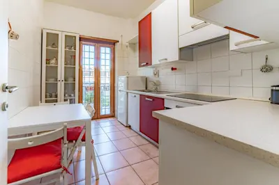 a kitchen with white appliances and red cabinets at Marta Suite - Metro Malatesta & Wi-Fi in Rome