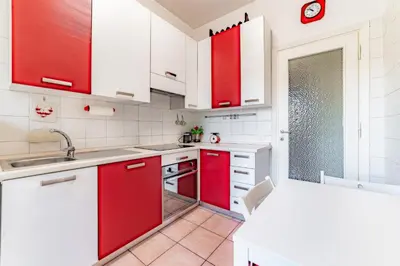a kitchen with red cabinets and white appliances at Marta Suite - Metro Malatesta & Wi-Fi in Rome