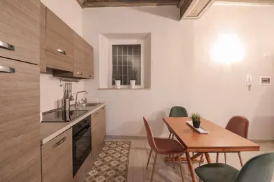 a kitchen with a wooden table and a dining room at Beautiful Apartment in the Heart of Rome in Rome