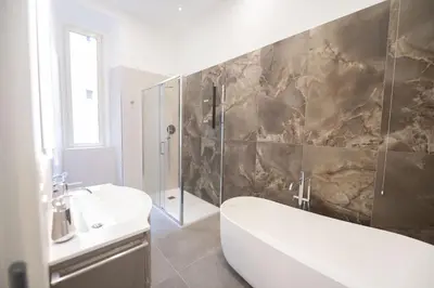 a bathroom with a tub and a sink and a shower at Splendor Eternal 3 BR Apartment in the City Center in Rome