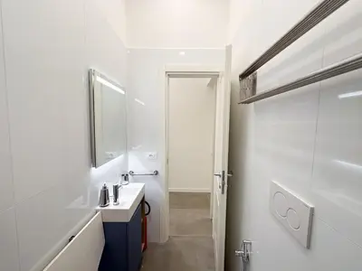a white bathroom with a sink and a mirror at Splendor Eternal 3 BR Apartment in the City Center in Rome