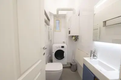 a white bathroom with a washing machine in it at Splendor Eternal 3 BR Apartment in the City Center in Rome