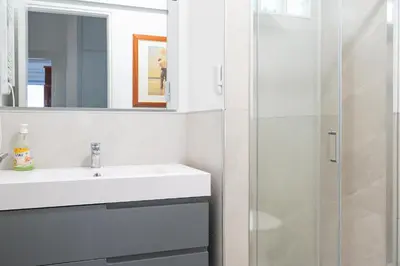 a white bathroom with a sink and a shower at Lion Renting Marconi in Rome