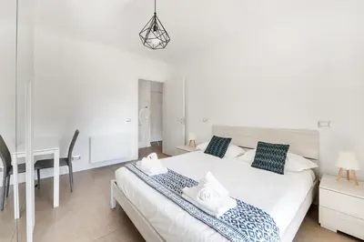 a white bedroom with a bed and a desk at Pigneto Terrace - Residenze Romanae in Rome