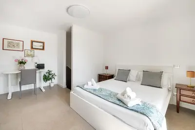 a bedroom with a white bed and a desk at Pigneto Terrace - Residenze Romanae in Rome