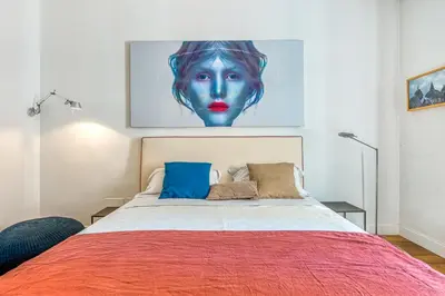 a bedroom with a bed with a painting on the wall at Skylife Eco-Luxe Trastevere Haven in Rome