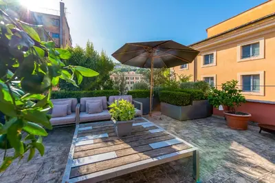 a patio with a table and an umbrella at Skylife Eco-Luxe Trastevere Haven in Rome