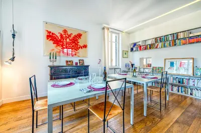 a dining room with a table and chairs and bookshelves at Skylife Eco-Luxe Trastevere Haven in Rome