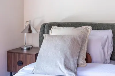 a bed with two pillows and a table with a lamp at iFlat Monti Life with Elegance, Comfort and Beauty in Rome