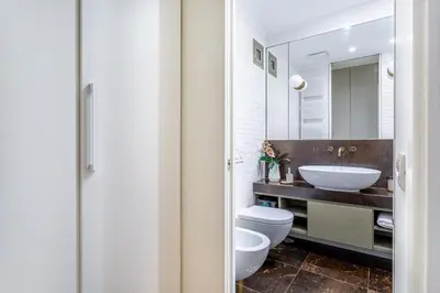 a bathroom with a sink and a toilet and a mirror at iFlat Monti Life with Elegance, Comfort and Beauty in Rome