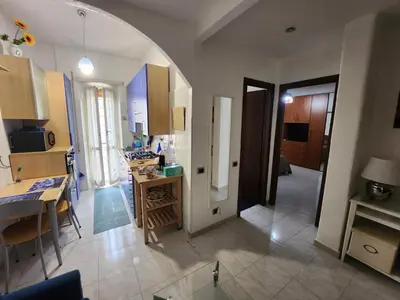 an open kitchen and dining room with an archway at La casetta di Marco in Rome