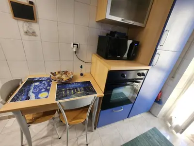 a small kitchen with a table and a stove at La casetta di Marco in Rome