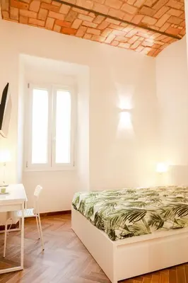 a bedroom with a bed and a table and a desk at La porta Magica, la casa tra le basiliche in Rome