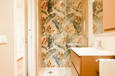 a bathroom with a wall mural of leaves at La porta Magica, la casa tra le basiliche in Rome