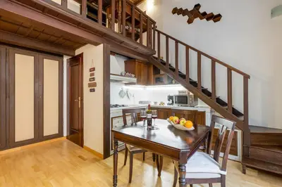 a kitchen with a table and chairs and a staircase at Loft Trastevere 2 floors in Rome