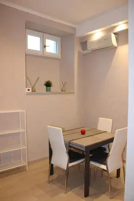 a dining room with a table and white chairs at il borghetto antico in Rome
