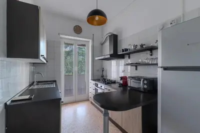 a white kitchen with a black counter top at Aura in Rome