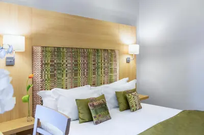 a bedroom with a large white bed with green pillows at Chic&Town Luxury Rooms Piazza del Popolo in Rome