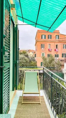 a hammock on a balcony with a view of a building at Borgo Felix - Authentic Roman Living in Quadraro in Rome