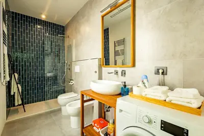 a bathroom with a sink and a toilet and a mirror at Borgo Felix - Authentic Roman Living in Quadraro in Rome