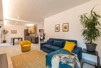 a living room with a blue couch and a yellow chair at Borgo Felix - Authentic Roman Living in Quadraro in Rome