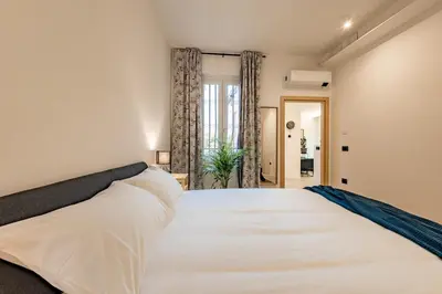a large white bed in a room with a window at Borgo Felix - Authentic Roman Living in Quadraro in Rome