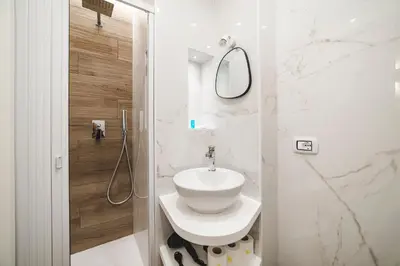 a white bathroom with a sink and a mirror at Monteverde Vatican in Rome