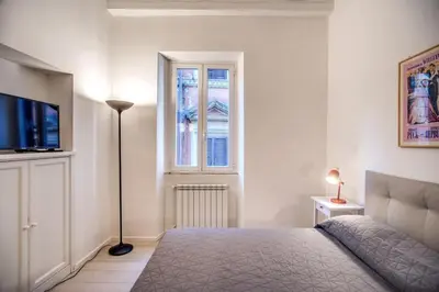 a bedroom with a bed and a tv and a window at Agnello Apartment in Rome