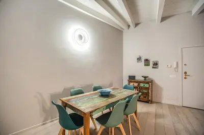 a dining room with a wooden table and green chairs at Agnello Apartment in Rome