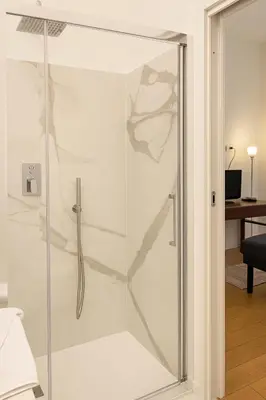a glass shower stall in a room with a desk at Casetta Beatrice Cozy Flat near Vatican in Rome