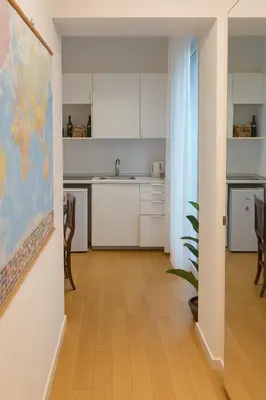 a kitchen with white cabinets and a map on the wall at Casetta Beatrice Cozy Flat near Vatican in Rome