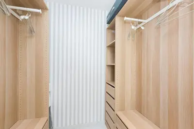 a walk in closet with wooden cabinets and a window at Boutique Domus Trastevere Penthouse in Rome