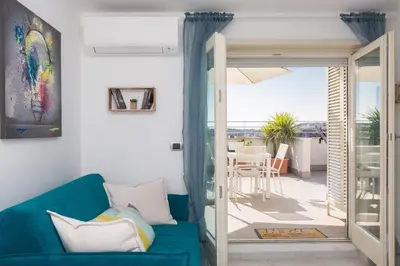 a living room with a blue couch and a balcony at Boutique Domus Trastevere Penthouse in Rome