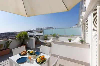 a balcony with a table and chairs on a roof at Boutique Domus Trastevere Penthouse in Rome