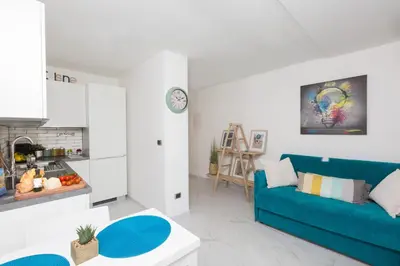 a living room with a blue couch and a kitchen at Boutique Domus Trastevere Penthouse in Rome