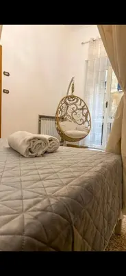 a bedroom with a bed and a chair next to a window at Pantheon Luxury Noble Apartment in Rome