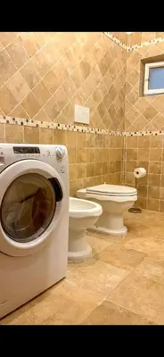 a bathroom with a washing machine and a toilet at Pantheon Luxury Noble Apartment in Rome