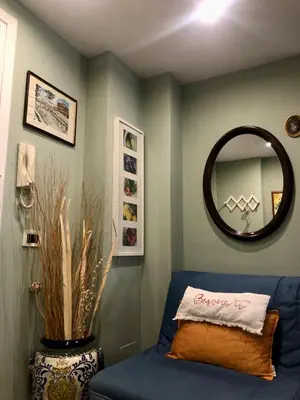 a living room with a blue couch and a mirror at Due Calzini in Rome
