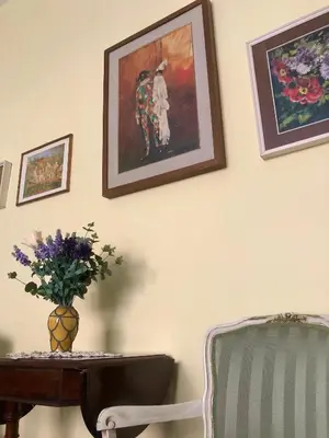 a table and a chair and a vase of flowers on a wall at Due Calzini in Rome
