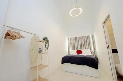 a small bedroom with a bed and a mirror at Principe Amedeo piano terra in Rome