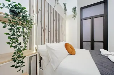 a bedroom with a white bed and a plant at Principe Amedeo piano terra in Rome