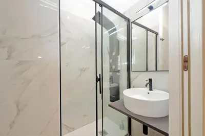 a bathroom with a sink and a glass shower at Principe Amedeo piano terra in Rome