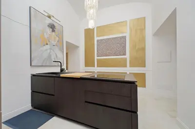 a room with a counter with a sink and paintings at Principe Amedeo piano terra in Rome