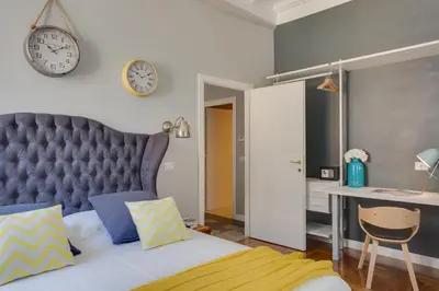 a bedroom with a bed and a clock on the wall at RomExperience Borgo Pio in Rome
