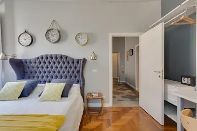 a bedroom with a bed with clocks on the wall at RomExperience Borgo Pio in Rome